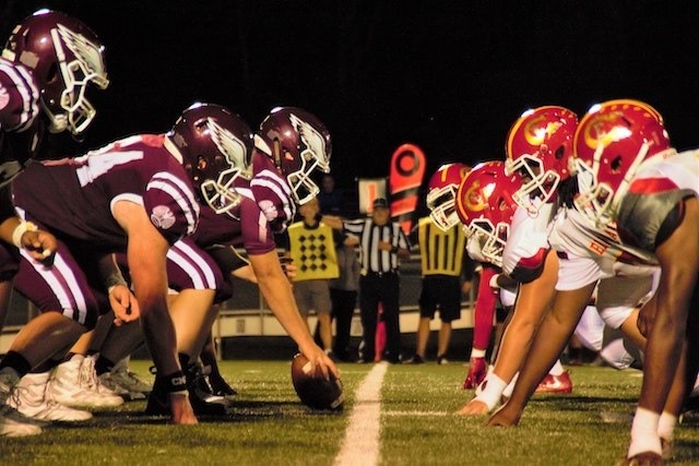 アメフトコートのセンターライン上で対面する二つのチーム